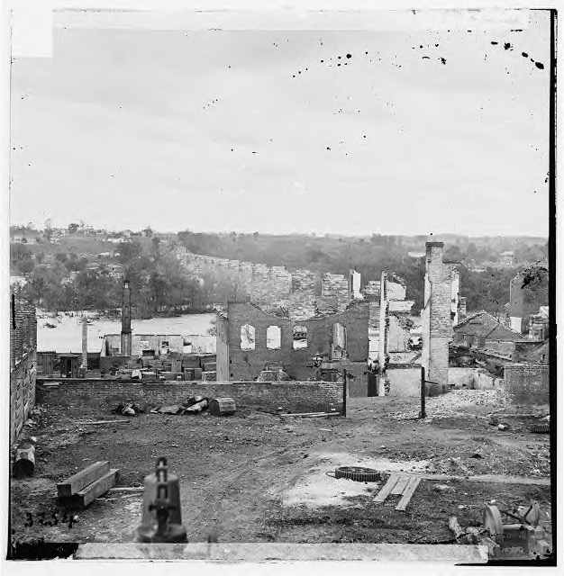 Ruins of the Richmond & Petersburg RR bridge into Richmond. The view is looking south, out of the city and over the James River. Since the stone piles had not been damaged (something very difficult to do), the repair of this bridge would not be particularly difficult.